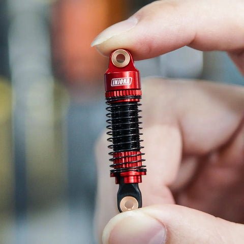 Threaded Shock Absorber Oil Damper 53mm for Redcat Ascent18 held by hand showcasing red CNC machined aluminum body