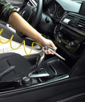 Person using Coiled Nylon Air Hose With Brass 1/4 Inch NPT Fittings to clean car interior, lightweight flexible air line