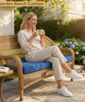 Woman sitting on a garden bench with a blue cushion, enjoying a drink, while a child plays on a patio surrounded by flowers.