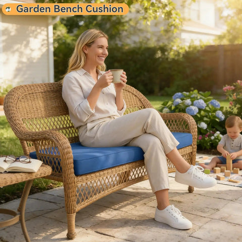 Woman sitting on a garden bench with a blue cushion, enjoying a drink, while a child plays on a patio surrounded by flowers.