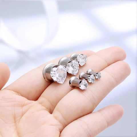Hand holding ASTM F136 Titanium 0G Heart CZ Ear Gauges Tunnels Plugs Set 8mm Pair for Ear Stretching Jewelry