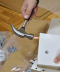 Person assembling furniture using 1000 Piece Five Sixteenth Inch Wooden Dowel Pins Set For Woodworking, with hammer and wood panels.