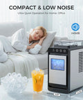 Countertop Portable Ice Maker With External Water Tank shown on table, glass of ice cubes and juice next to a sleeping person on sofa.
