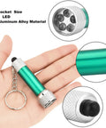 Set Of 30 Mini LED Keychain Flashlights With 5 Bulbs, Ultra Portable Pocket Lights For Camping in hand, green aluminum, close-up view.