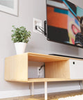 Wall Mounted TV Cord Hider With 2 AC Outlets And 2 USB A Ports Hide Cables Behind The Wall Includes Template Saw And Low Profile Extension Cord White behind a mounted TV and media console.