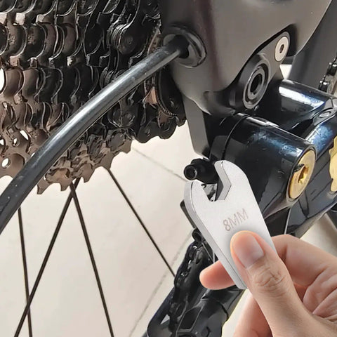 Rock Solid 8MM Disc Brake Spanner Heavy Duty Precision Steel Construction Designed Slick For Hydraulic Cable Adjustment And Bike Chain Tune Ups Goes Hard On Every Mechanic Setup held near a bike's brake cable.