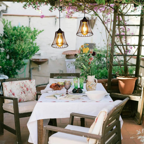 Three Pack Battery Operated Outdoor Chandelier Pendant Lights With Rustic Black Metal Bell Shade for gazebo patio porch decor above a table.