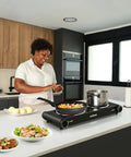 Woman using Dual Infrared 1800W Hot Plate Portable Electric Stove With Glass Cooktop And Adjustable Temperature Control Stainless Steel Double Burner
