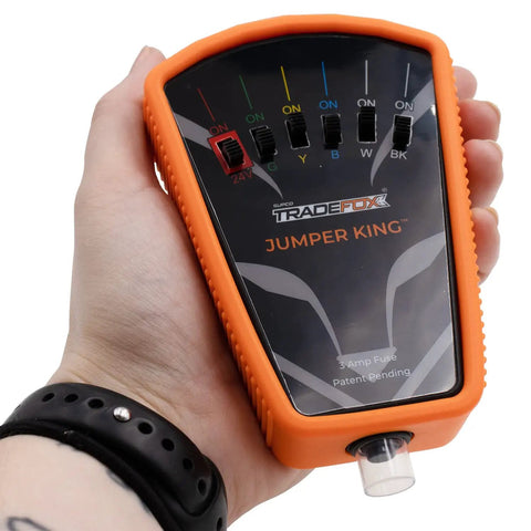 Person holding a Low Voltage Fused Multi Jumper With Selector Switches For Thermostat Bypass And Quick Fix Short Cycle Prevention In 0 To 30 VAC DC Systems Includes Spade Adapters.
