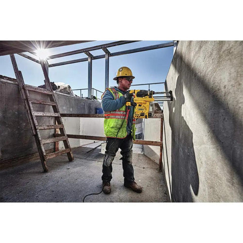 Worker using onboard dust extractor for 1-1/8-Inch SDS Plus rotary hammers with clear dust box for mess-free drilling