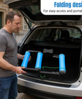 Person placing Whisper Quiet Indoor Bike Trainer With Foldable Stand into car trunk for easy storage and transport.