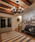 Black Farmhouse Chandelier With Six Clear Glass Shades Hanging Over Dining Table Featuring Sturdy Metal Frame And Sleek Modern Design That Hits Different For A Killer Centerpiece Vibe In Any Home Space in an entryway with a rug.
