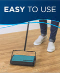Super Lightweight Cordless Floor Sweeper With Dual Bottom Dump Bins For Snap Up Messes And Dust Clumps On Hardwood Tile And Area Rugs Compact Push Broom Cleaner In Teal in use on hardwood floor.