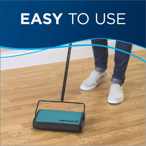 Super Lightweight Cordless Floor Sweeper With Dual Bottom Dump Bins For Snap Up Messes And Dust Clumps On Hardwood Tile And Area Rugs Compact Push Broom Cleaner In Teal in use on hardwood floor.