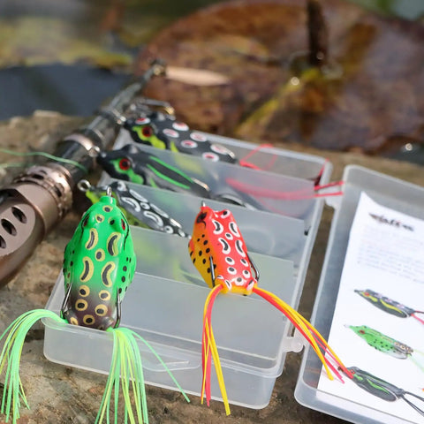 Five Piece Topwater Frog Lures Set For Freshwater Fishing Catch Bass And More Ray Frog Soft Baits in tackle box on rock