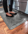 Person standing on Ergonomic Anti-Fatigue Floor Mat For Home Kitchen Garage And Office Standing Desks Polyurethane Water-Resistant Made In USA Bella Collection With Subtle Floral Design For All-Day Comfort