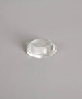 Clear polyurethane self-adhesive furniture foot, 0.5 in dia x 0.14 in tall, close-up front view
