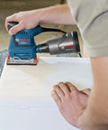 Person using GSS20-40 One Quarter Sheet Orbital Finishing Sander, Palm Sized, 2 Amp Motor, on wood surface, dust collection mode