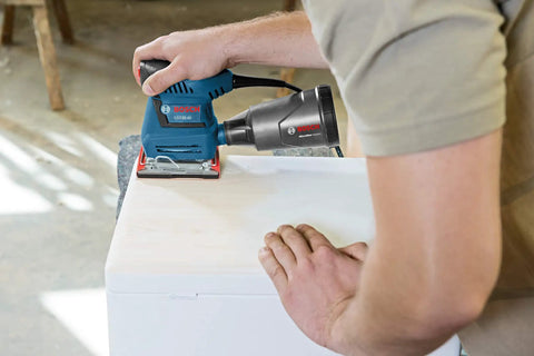 Person using GSS20-40 One Quarter Sheet Orbital Finishing Sander, Palm Sized, 2 Amp Motor, on wood surface, dust collection mode