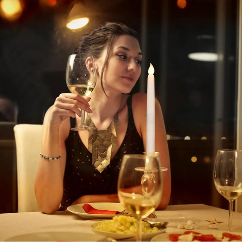 Woman dining with 24 Pack Flameless Taper Candles With Remote And Timer, 11 Inch LED Battery Operated Candles, ivory on table