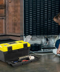 16 Inch Plastic Toolbox With Handle Portable Toolbox With Removable Tray and Lockable Design Built Tough For Home Workshop or Garage With Small Parts Box in Black and Yellow next to a repairman working.