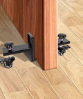 Close-up of Professional Grade Heavy Duty Door Panel Cart with swivel wheels attaching to a door frame on wooden floor.