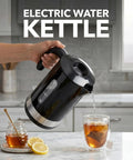 Rapid Fire 1500W Electric Kettle With 1.8 Liter Capacity Bpa Free Build pouring hot water into a glass cup with tea.
