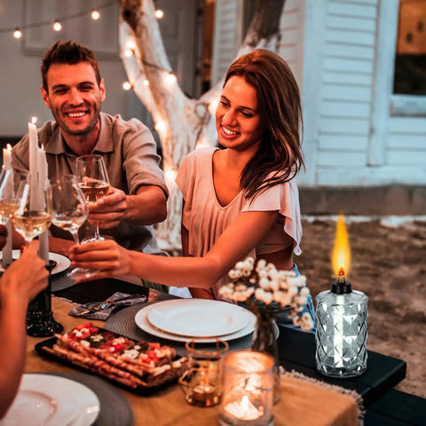 Glass Table Top Torches Four Pack Outdoor Citronella Torches With 12oz Fuel Capacity Refillable Wick And Cap Included next to people dining outdoors.