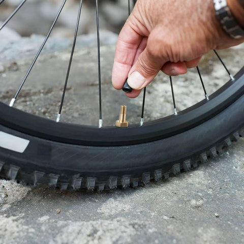 Person attaching cap to Two Pack One Quarter Inch NPT Tank Valve To Standard Schrader Brass Valve Adapter on bicycle tire
