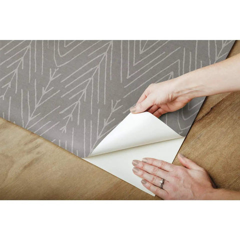 Hands peeling Charcoal Gray Twig Hygge Herringbone Peel And Stick Wallpaper 20.5 Inches Wide 16.5 Feet Long Removable No Residue
