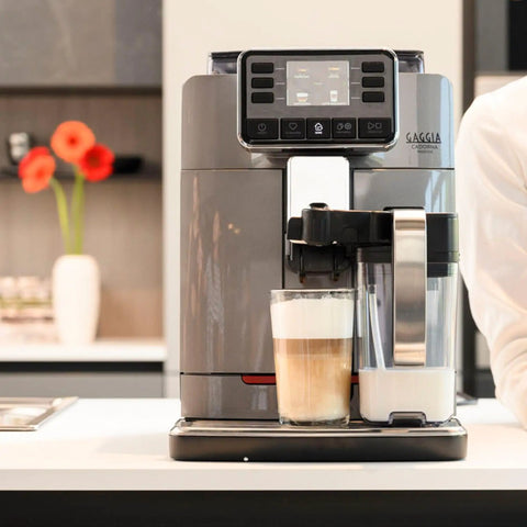 Top Shelf Super Automatic Espresso Machine Crafting One Touch Cappuccino Latte Macchiato Ristretto And Flat White For Your Kitchen Game Changing Setup In Anthracite with glass of latte and milk frother.