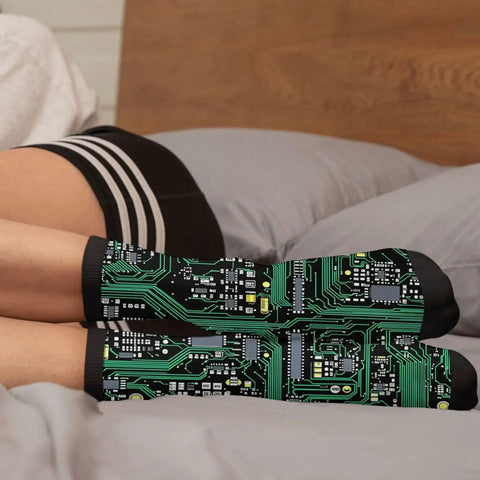 Printed Circuit Board Socks Dope Nerdy Crew Socks For Men And Women With Cushioned Soles Soft Polyester Spandex Blend One Size Fits Most Funny Tech Gift For Geeks And Gamers, worn on feet resting on bed, circuit pattern visible