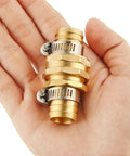 Close-up of Brass Garden Hose Repair Kit With Clamps For Three Quarter Inch Hoses in hand, showing metal connectors and clamps.