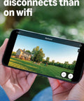Person holding a phone displaying a backyard view, highlighting the Top Tier Wireless Outdoor Security Kit With Four Super Clear Cameras Plus A 2K Battery Video Doorbell Delivering Extended Sync Coverage So Your Digs Stay Covered Without Any Tech Worries.