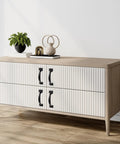 White dresser with ribbed drawers and black six-piece 5 inch rustic gate handle set, placed in a modern living room corner.