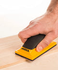 Ergonomic Pro Grade 2.75 by 5 Inch Dust Free Hand Sanding Block With 13 Hole Hook And Loop System in use on wooden surface
