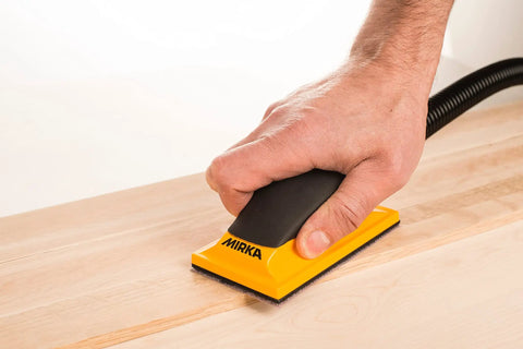 Ergonomic Pro Grade 2.75 by 5 Inch Dust Free Hand Sanding Block With 13 Hole Hook And Loop System in use on wooden surface