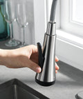 Close-up of hand holding sprayer of High Arc Kitchen Faucet With Pull Down Sprayer Single Handle Sink Faucet In Brushed Nickel