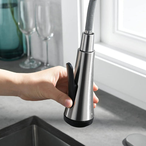 Close-up of hand holding sprayer of High Arc Kitchen Faucet With Pull Down Sprayer Single Handle Sink Faucet In Brushed Nickel