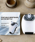 Silicone Wrist Bottle With Hand Strap For Ultra Portable Hydration On The Go shown with packaging on a table