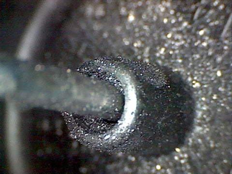 Graphite Dry Lube for Wood Derby Cars with Tungsten Moly Boron Blend applied to axle, showing micro lubrication on wheel contact.