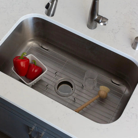 Stainless Steel Sink Protector Grid And Mat For Kitchen Sinks 18 X 12 X 1 Inch in use with vegetables and cleaning brush.