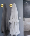 Beefy Heavy Duty Wall Mounted Brushed Gold Stainless Steel Coat Hooks And Towel Hooks Set Four Pack For Bathroom Kitchen Garage Living Room Hotel Rustproof 304 Stainless Steel Robe Hanger Holder in use with bathrobe and towel hanging.