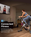 Woman using Prime Magnetic Belt Drive Indoor Stationary Cycling Bike With Bluetooth App Connectivity And Two Stage Transmission System