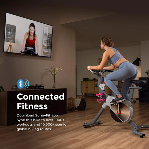 Woman using Prime Magnetic Belt Drive Indoor Stationary Cycling Bike With Bluetooth App Connectivity And Two Stage Transmission System