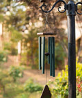 Wind chime suspended from a pole, showcasing green tubes and wooden top, highlighting usage with 20 Pack Stainless Steel Swivel Hooks For Wind Spinners And Patio Deck Heavy Duty Rustproof S Clips Silver Premium Grade Garden Yard Hanging Hardware Straight Up Bombproof Build.