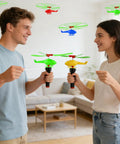 Two people launching colorful helicopters from the Colorful Helicopters And Airplanes Set With Launcher, 20 Flying Toys For Party Favors.