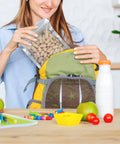 Person placing 50 Pack Mylar Bags For Food Storage With Clear Window In 1 Quart Size into backpack