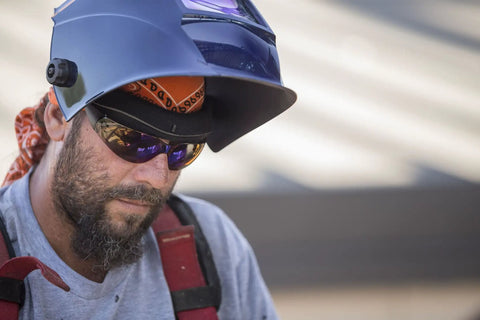 Welder wearing Wham 3030GB Solar Powered Welding Helmet With Pivot Headgear, focusing on welding task outdoors
