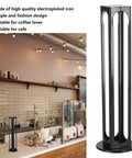 32 Pod Coffee Capsule Holder, 360 Degree Rotating Iron Stand in a cafe setting with sleek black finish